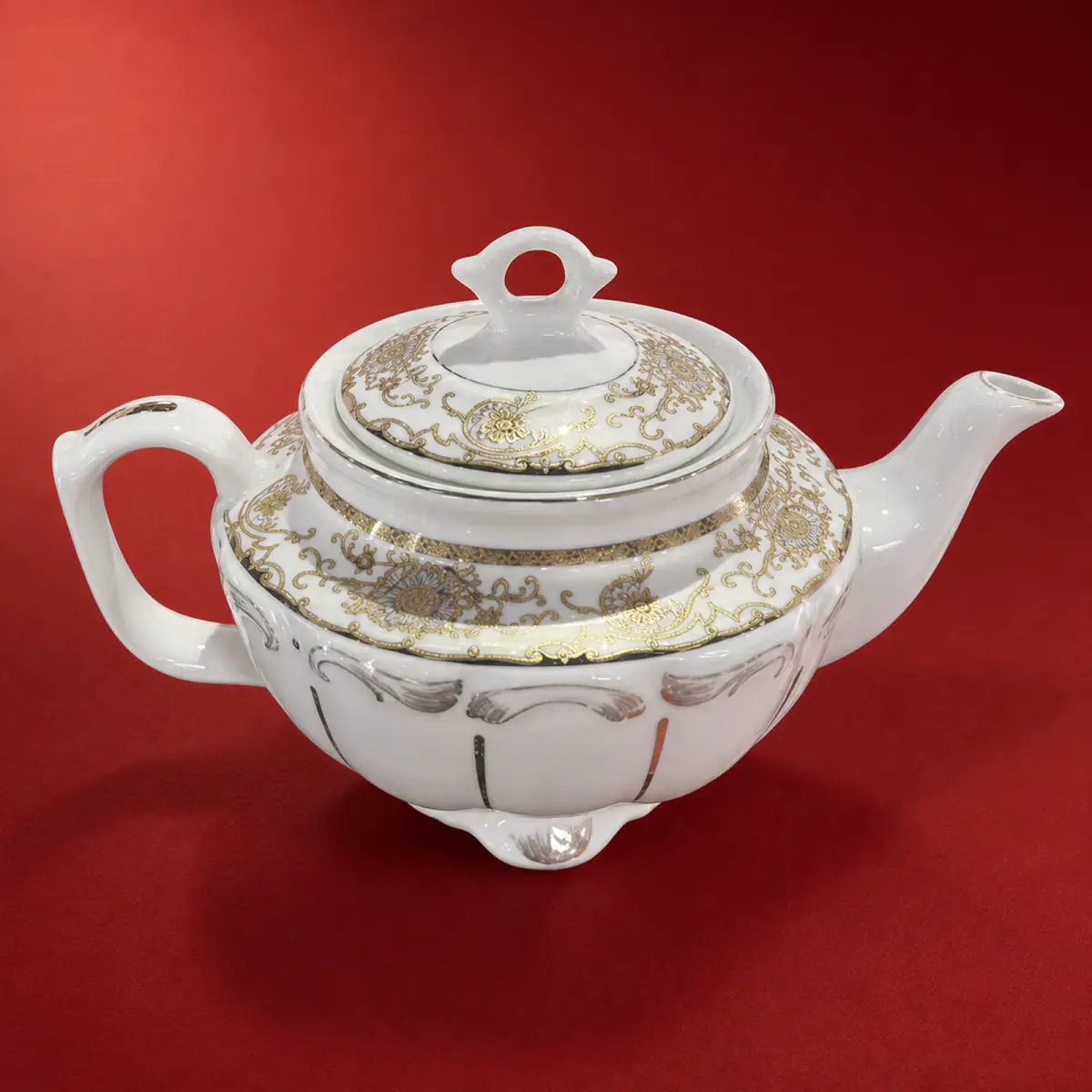 Gold Decal Teapot shown on a red studio background