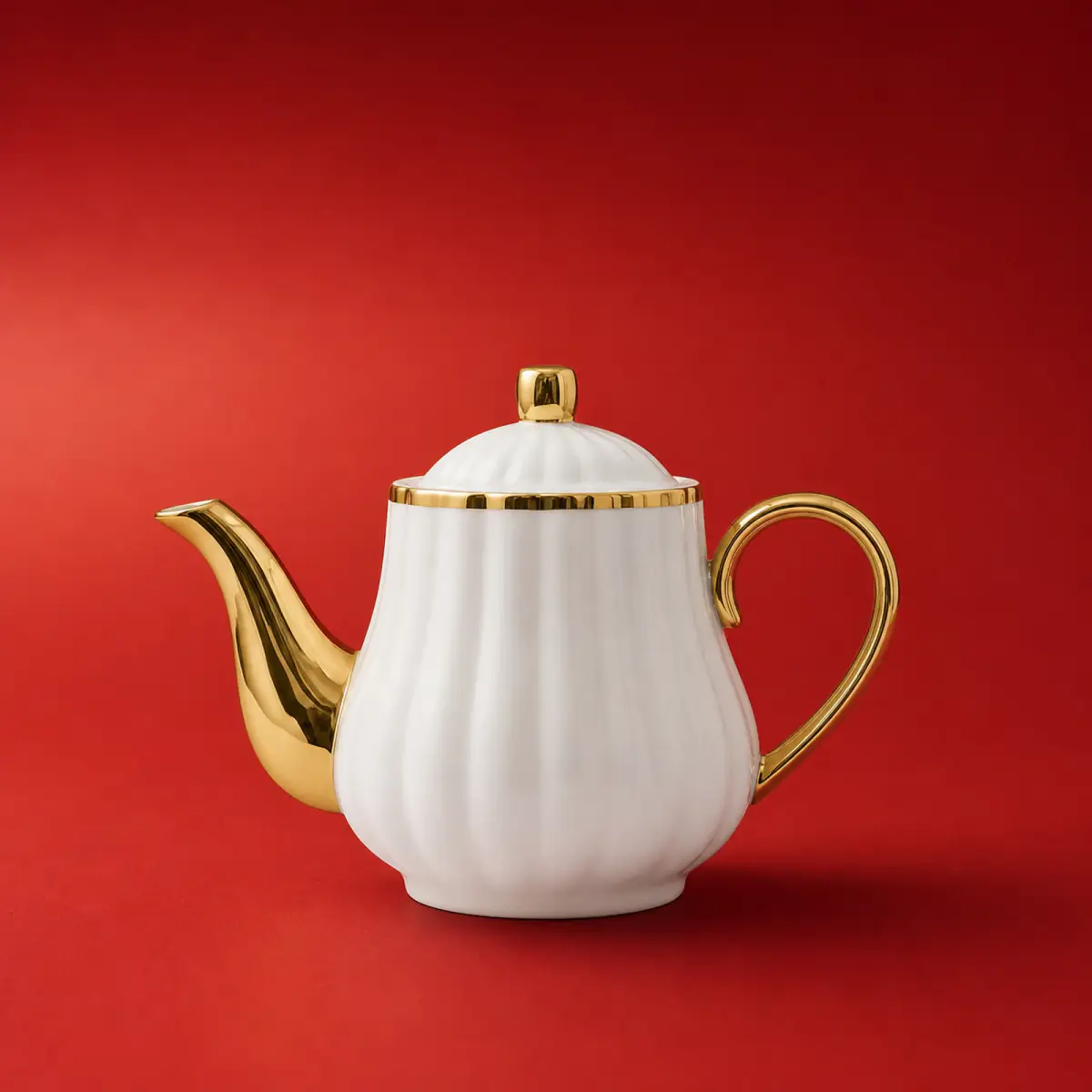 Gold Trim Ceramic Teapot shown on a red studio background